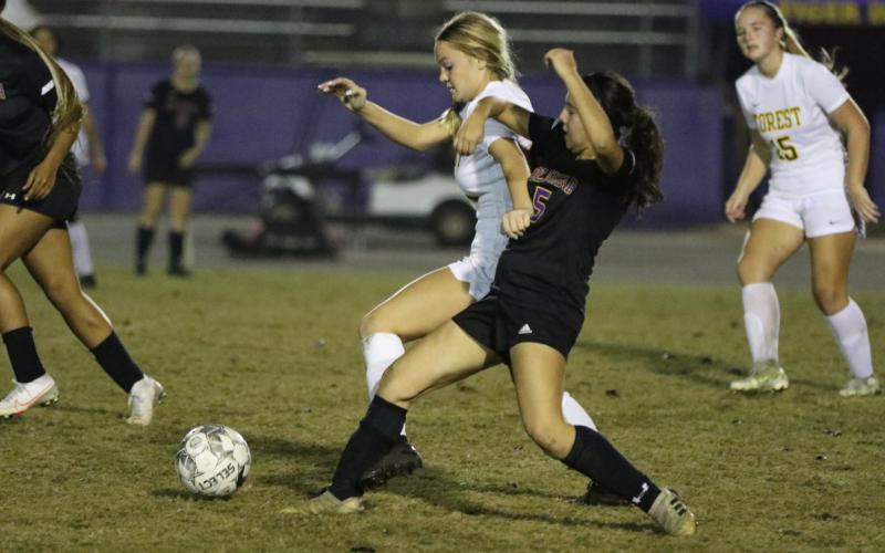 Columbia’s Carla Medina fights for possession of the ball with Forest’s Rylynn Robinson on Friday. (MORGAN MCMULLEN/Lake City Reporter)