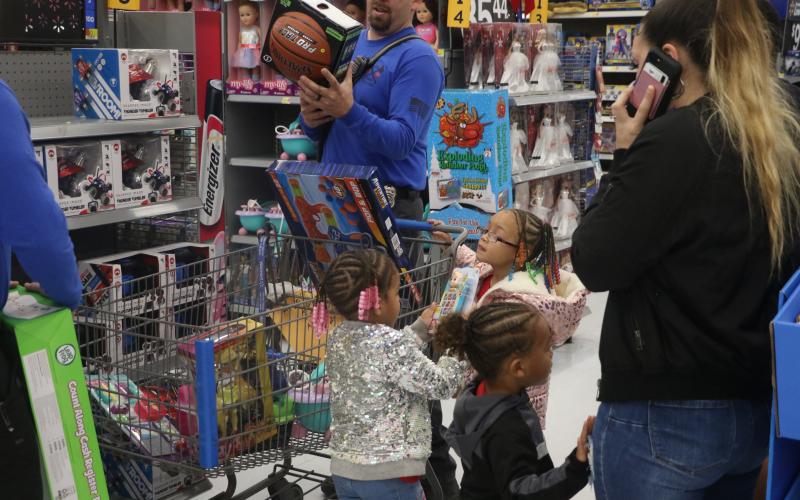 The Lanier family children look over some of the toys they selected during Monday’s ‘Shop with a Cop’ event. (MORGAN MCMULLEN/Lake City Reporter)