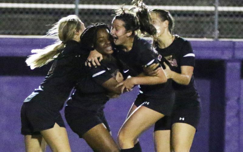 Columbia players celebrate with Olivia Kelly (middle left) after she scored a goal against Gainesville on Tuesday night. (MORGAN MCMULLEN/Lake City Reporter)