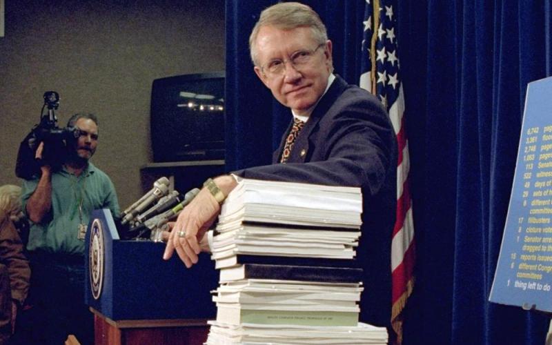 Sen. Harry Reid, D-Nev., leans on a stack of documents pertaining to campaign finance reform during a Capitol Hill news conference on Dec. 3, 1996, where the Democratic leadership for the 105th Congress was announced. (DENNIS COOK/Associated Press)