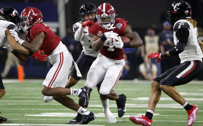 Alabama running back Brian Robinson Jr. runs for a first down as Cincinnati linebacker Deshawn Pace reaches from behind to tackle him during the Cotton Bowl College Football Playoff semifinal game on Friday in Arlington, Texas. Alabama won 27-6. (MICHAEL AINSWORTH/Associated Press)