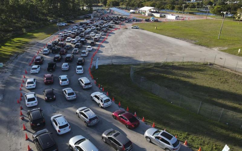 In this photo taken by a drone, cars wait in long lines at a drive-up covid-19 testing center at Tropical Park, Wednesday, Dec. 29, 2021, in Miami. (REBECCA BLACKWELL/Associated Press)