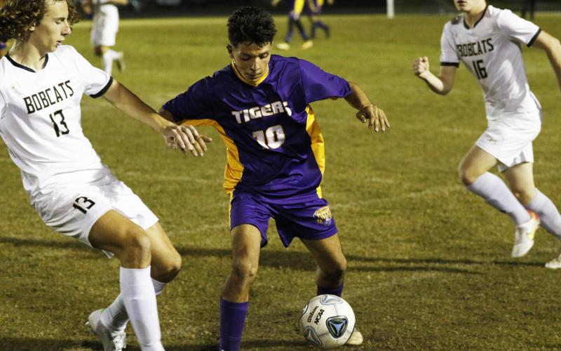 Jason Caballero gathers possession of the ball as Buchholz’s Eduardo Santos rushes in to defend on Friday night. (JORDAN KROEGER/Lake City Reporter)