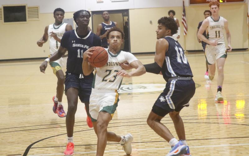 FGC guard Jazan Johnson drives past Santa Fe College guard Nicolas McClain on Tuesday night at the Howard Center. (JORDAN KROEGER/Lake City Reporter)