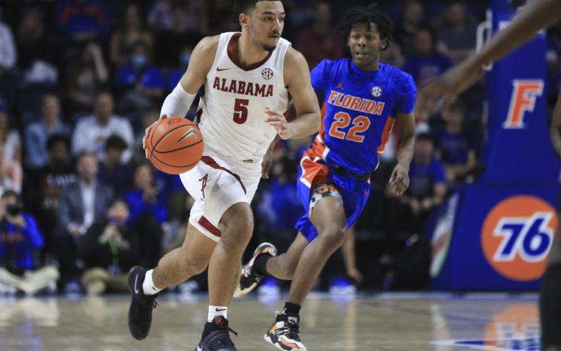 Alabama guard Jaden Shackelford (5) brings the ball up past Florida guard Tyree Appleby (22) during the first half of an NCAA college basketball game Wednesday, Jan. 5, 2022, in Gainesville. (MATT STAMEY/Associated Press)