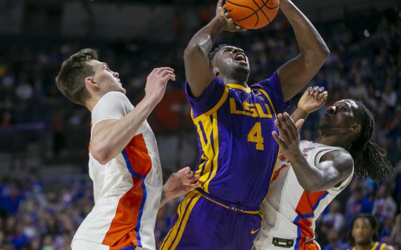 LSU forward Darius Days drives for the basket between Florida forward Colin Castleton, left, and Florida forward Anthony Duruji during Wednesday's game in Gainesville. (ALAN YOUNGBLOOD/Associated Press)