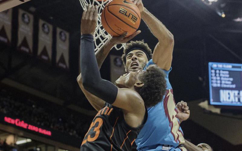 Miami guard Kameron McGusty (23) is blocked by Florida State guard Anthony Polite (2) during Tuesday's game at the Tucker Civic Center in Tallahassee. (ALICIA DEVINE/Tallahassee Democrat via AP)