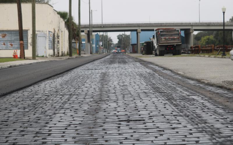 A layer of sealant covers brick pavers on Northwest Railroad Street on Wednesday afternoon as Anderson Columbia Construction Company workers resurface the roadway. (TONY BRITT/Lake City Reporter)