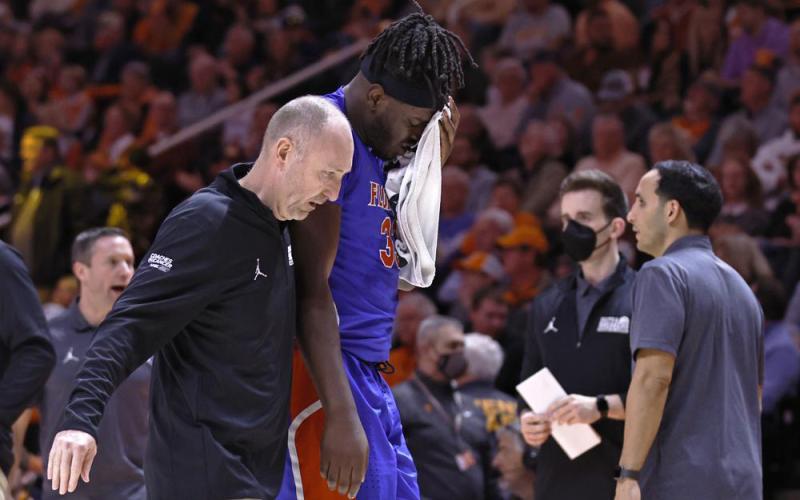 Florida center Jason Jitoboh is led off the court after being injured on a play against Tennessee on Wednesday in Knoxville, Tenn. (WADE PAYNE/Associated Press)