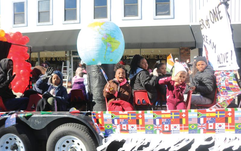 Children on the New Dayspring Missionary Baptist Church float hold flags representing various nations during the Dr. Martin Luther King Jr. parade on Jan. 20, 2020. (FILE)