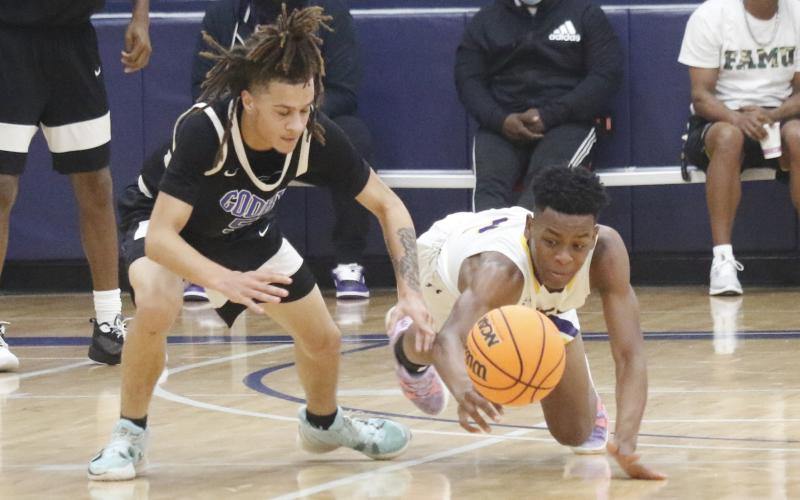 Columbia guard Jerome Carter dives for a loose ball against Godby during the Hitchcock’s Challenge at Legacy Park on Dec. 30 in Alachua. (JORDAN KROEGER/Lake City Reporter).