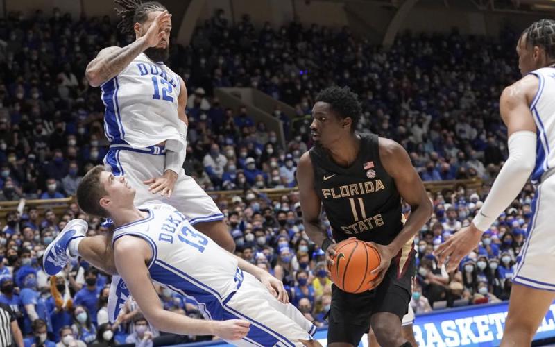 Duke forward Joey Baker (13) draws a charge against Florida State center Tanor Ngom (11) while Duke forward Theo John (12) defends during Saturday’s game in Durham, N.C. (GERRY BROOME/Associated Press)