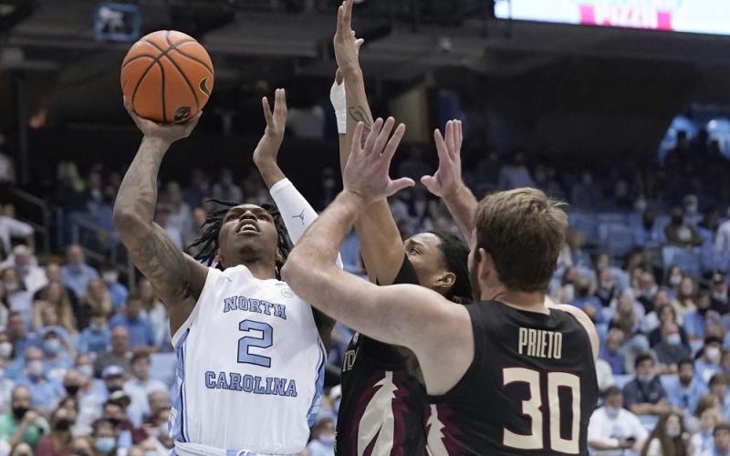 North Carolina guard Caleb Love (2) shoots against Florida State forward Harrison Prieto (30) and guard Caleb Mills during Saturday’s game in Chapel Hill, N.C. (GERRY BROOME/Associated Press)