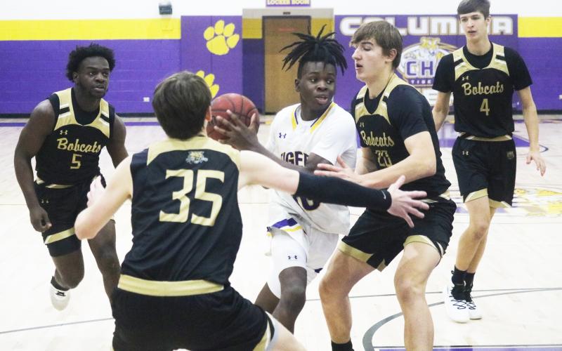 Columbia guard Isaac Broxey drives to the basket as Buchholz forwards Anthony Wilkie (20) and Palmer Walton (35) defend during Tuesday’s District 3-6A quarterfinal. (JORDAN KROEGER/Lake City Reporter)