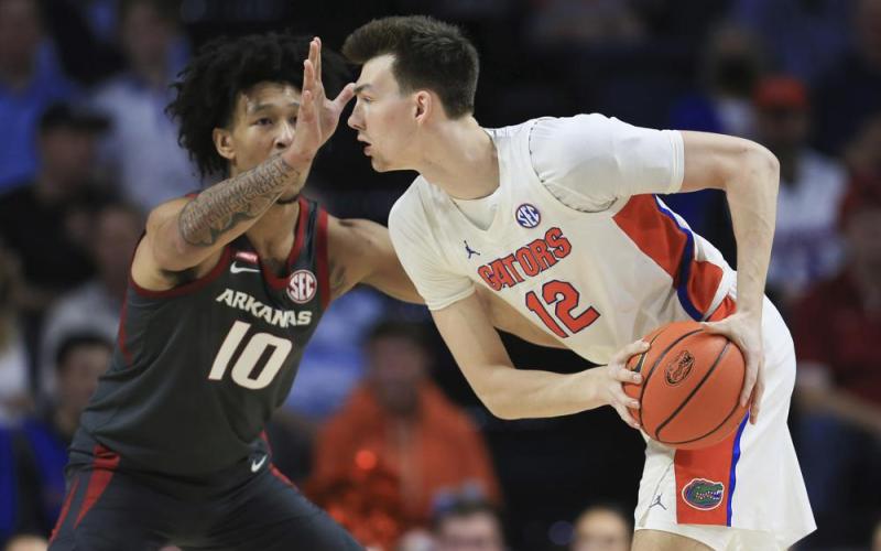 Arkansas forward Jaylin Williams (10) defends against Florida forward Colin Castleton (12) during Tuesday's game in Gainesville. (MATT STAMEY/Associated Press)