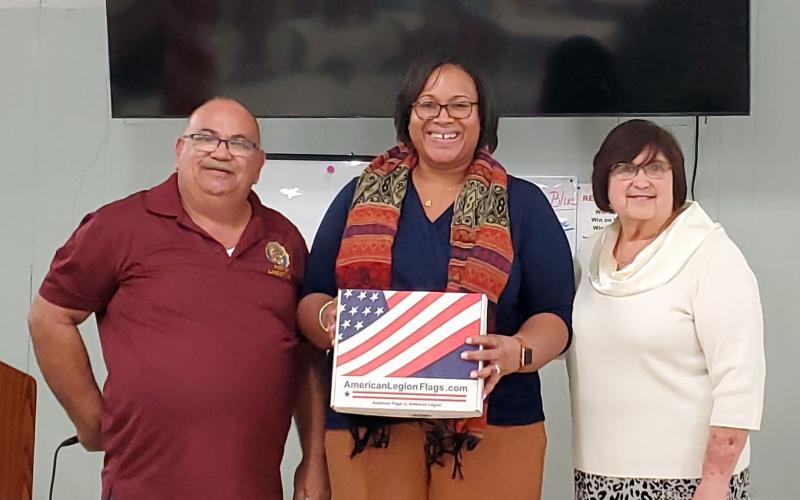 Columbia County Schools Assistant Superintendent Hope Jernigan (center) was presented with new American flags for district schools by American Legion Post Commander Rick Cabrera (left) and Irma Wehrli, Auxiliary Board member. (COURTESY)