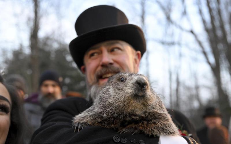Groundhog Club handler A.J. Dereume holds Punxsutawney Phil, the weather prognosticating groundhog, during the 136th celebration of Groundhog Day on Gobbler’s Knob in Punxsutawney, Pa., on Wednesday. Phil’s handlers said that the groundhog has forecast six more weeks of winter. (BARRY REEGER/Associated Press)