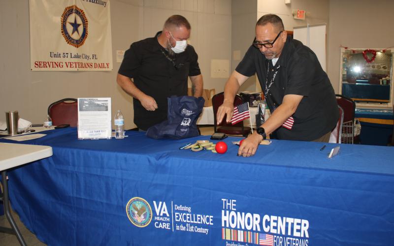 A pair of VA associates set up a table at American Legion Post No. 57 ahead of Thursday’s event. (TONY BRITT/Lake City Reporter)