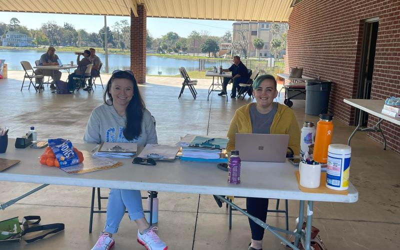 Volunteers sit at a makeshift desk at Wilson Park during a Florida drivers license restoration event. (COURTESY)