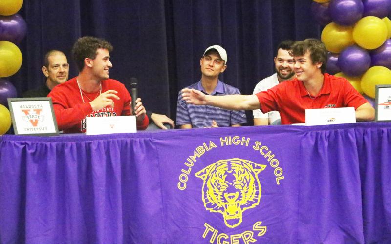 Columbia golfer Zach Shaw (right) reaches for the microphone from teammate Ty Folsom as the two share a laugh during Thursday’s signing ceremony. (MORGAN MCMULLEN/Lake City Reporter)