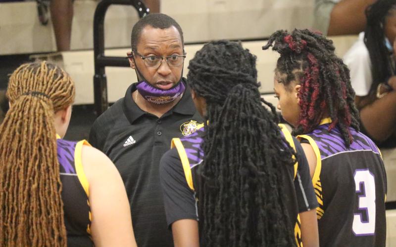 Columbia head coach Anthony Perry talks to guard Na'Haviya Paxton (middle) during a timeout of the District 3-6A championship game against Gainesville on Friday. (JORDAN KROEGER/Lake City Reporter)