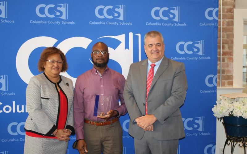 Narrie Smith (from left), Columbia School Board Chair, stands with Virgil Scippio, custodian supervisor at the school district administration building and Lex Carswell, superintendent of schools after Scippio was recognized as the 2022 Columbia School District School Related Employee of the Year during a Thursday afternoon ceremony at the Blanche Hotel. (TONY BRITT/Lake City Reporter)