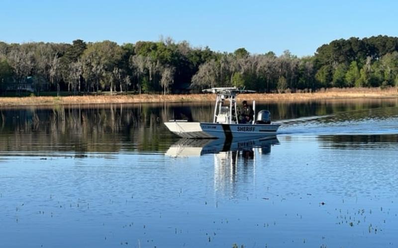 A Suwannee County Sheriff’s Department watercraft searches for the remains of Paul Gibson. Patrols found the 35-year-old’s body in Peacock Lake on Monday. (COURTESY)