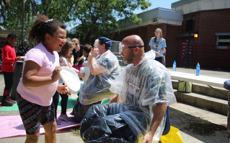 Melrose Park Elementary School student Aylin Alvarez (left) reacts after smearing Assistant Principal Stephen Smithy with a whipped cream pie. (TONY BRITT/Lake City Reporter)