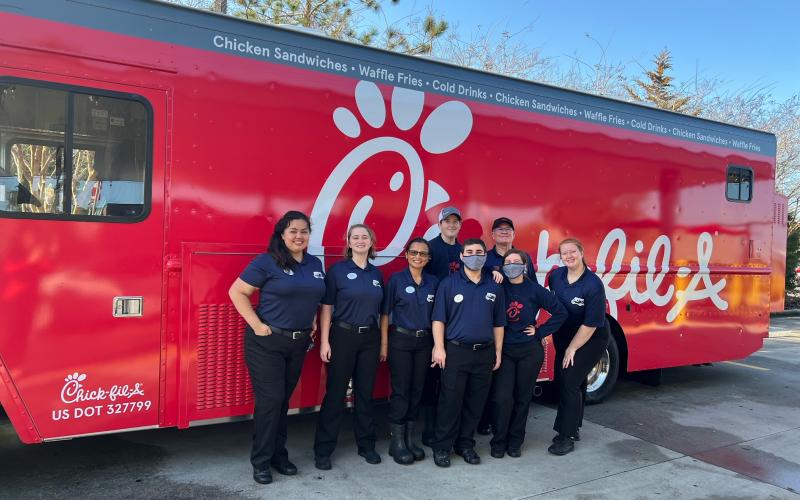 Chick-fil-A associates pose in front of the new food truck that will be serving up fast food treats. (COURTESY)