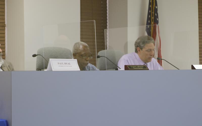 Councilman Eugene Jefferson (left) listens as Todd Sampson speaks during Tuesday’s city council meeting. (JAMIE WACHTER/Lake City Reporter)