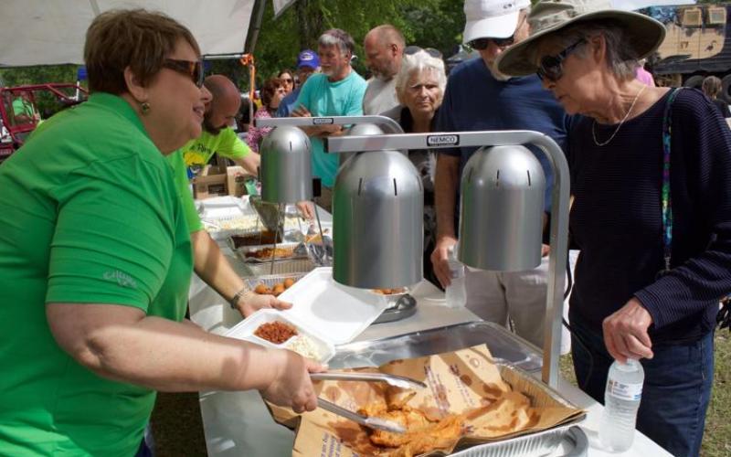 A volunteer serves up some fried catfish during a previous year’s Suwannee River Catfish Festival in Branford. (Suwannee Democrat File)