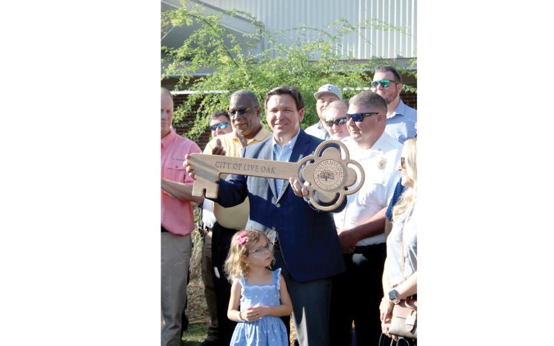 Governor Ron DeSantis holds up the key to the City of Live Oak at the opening ceremonies of the Suwannee County Fair. Live Oak Mayor Frank Davis presented the key, which was made out of a 300-year-old oak tree by Marine Corps veteran John Berube, to DeSantis. (TONY BRITT/Lake City Reporter)