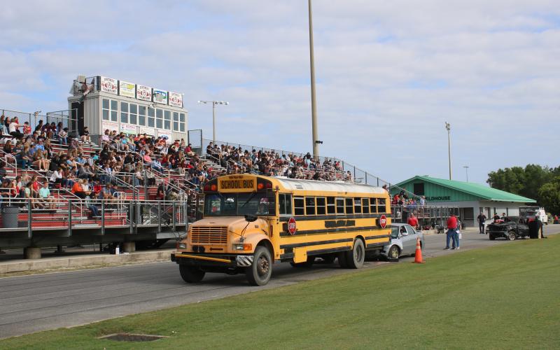 Fort White High students watch as a car has wrecked into the back of a school bus during a mock crash demonstration Thursday at the school. (TONY BRITT/Lake City Reporter)