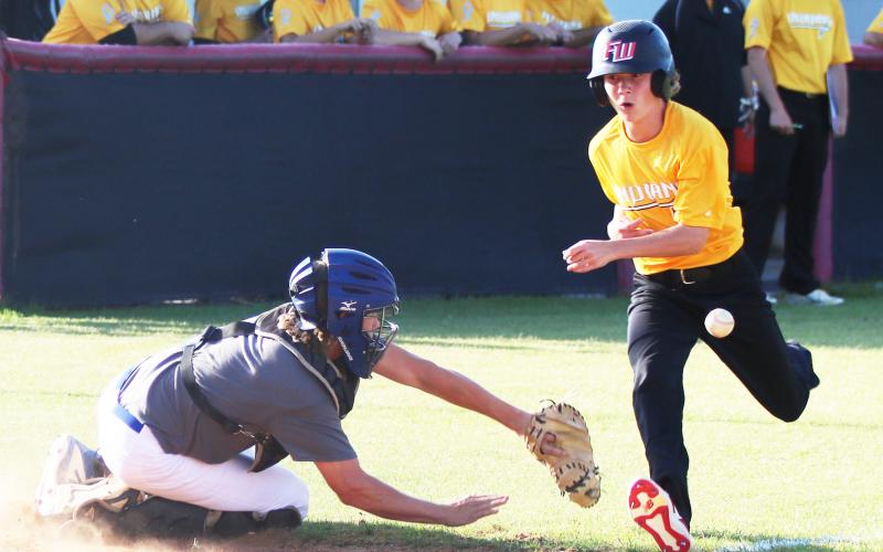 Fort White’s Patrick Kennedy beats a throw to home plate to score against Keystone Heights on Thursday. (JORDAN KROEGER/Lake City Reporter)