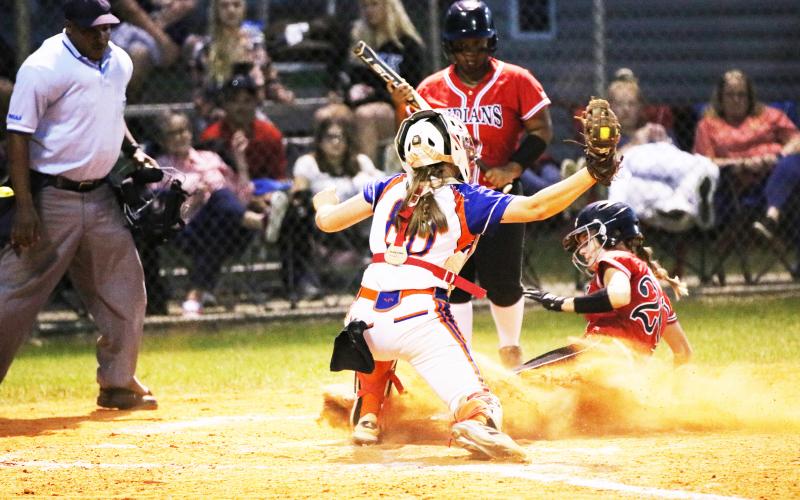 Fort White’s Madalyn Keen slides safely into home plate to beat the tag from Branford catcher Morgan Brennan as N’Coreyia Atkins looks on during Wednesday game. (JORDAN KROEGER/Lake City Reporter)