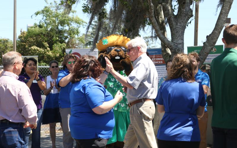 Dr. Scott Angle (right) gets a high-five from county extension director Heather Janney in front of Bellamy Beaver Friday afternoon. (MORGAN MCMULLEN/Lake City Reporter)