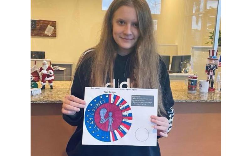Ridgeview High School student Gracie McCann shows off the winning design in Clay County’s ‘I Voted’ sticker design contest. (COURTESY)