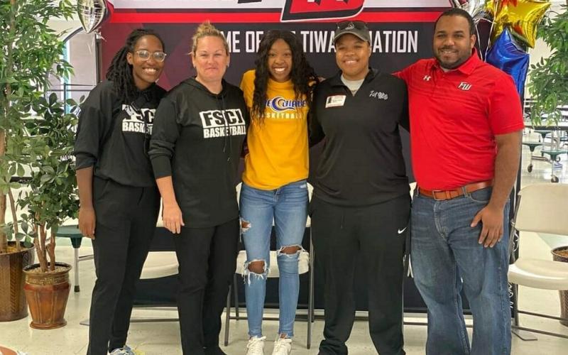 Fort White guard Jacovya Major (middle) signed her letter of intent to play at Florida State College at Jacksonville on Tuesday. Major is pictured with FSCJ assistant coach Jessica Eaton (left), FSCJ head coach Diane Couch (middle left), Fort White assistant coach Bregay Harris (middle right) and Fort White head coach DeShay Harris (right). (COURTESY)