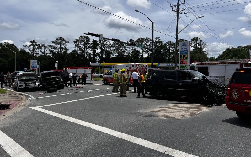 First responders clean up the intersection of SE Baya Drive and State Road 100 on Monday afternoon following a three-vehicle accident, including a Lake City Police Department SUV. (JAMIE WACHTER/Lake City Reporter)