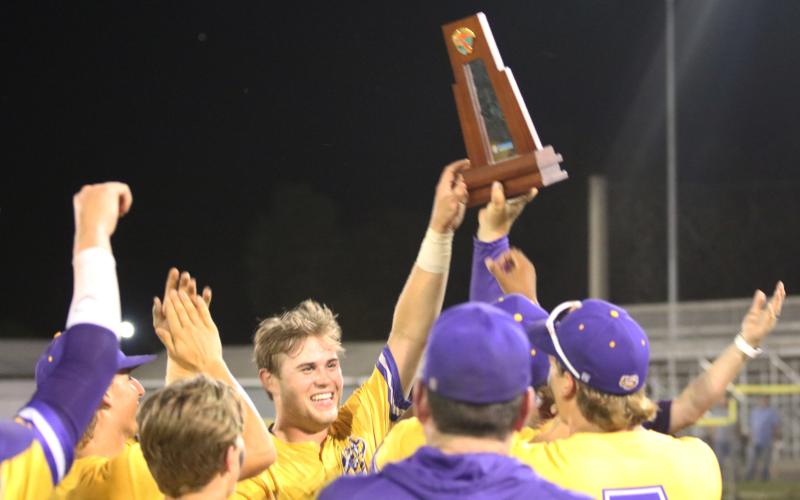 Columbia’s Brent Howard raises the District 3-5A trophy after the Tigers defeated St. Augustine 11-2 on Thursday. (JORDAN KROEGER/Lake City Reporter)