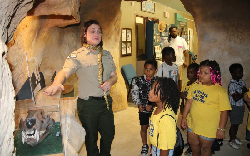 Corie Register, an employee at Ichetucknee Springs State Park, tells Niblack Elementary School students about the American Lion Skull display at the park’s education center Wednesday morning. (TONY BRITT/Lake City Reporter)