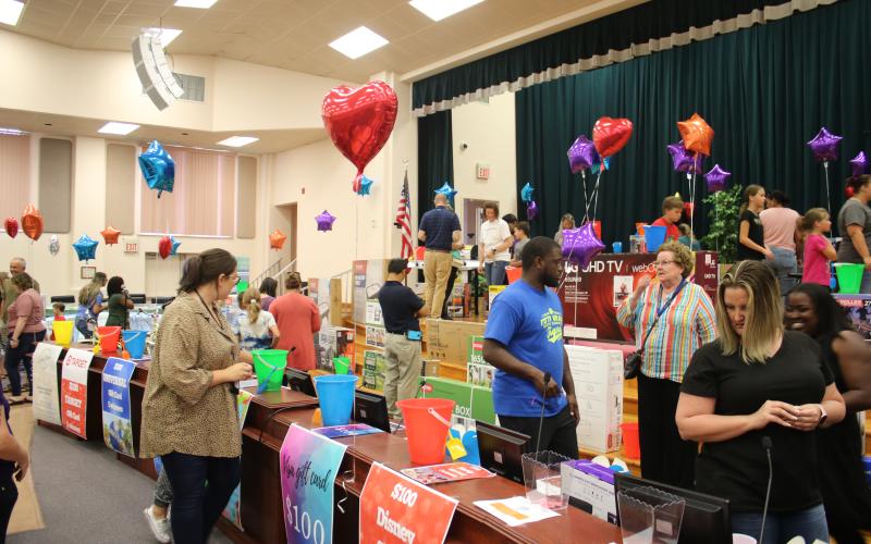 Columbia County School District employees peruse the 500 items in the district auditorium as part of the Employee Appreciation Extravaganza. (TONY BRITT/Lake City Reporter)
