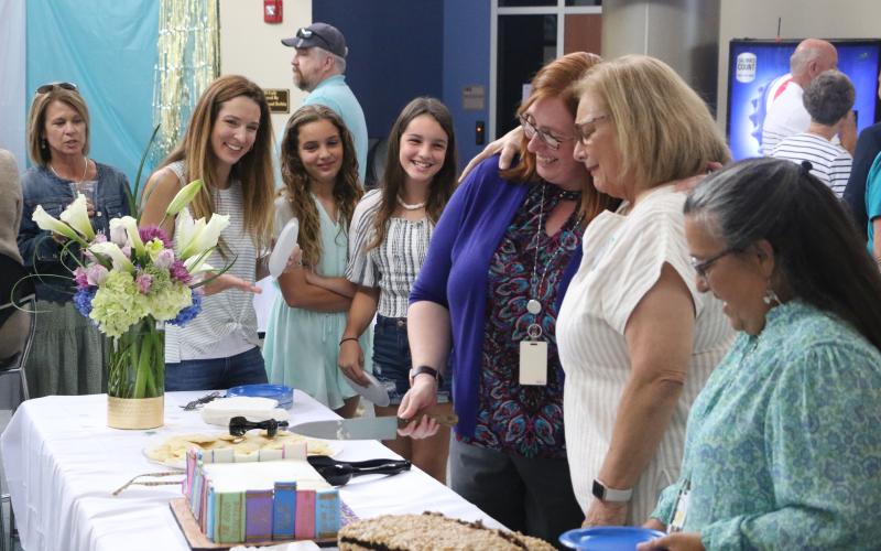 Jo Ann Bailey (second from right) hugs FGC Library Director Christine Boatright alongside Bailey’s daughter Jana Robinson (left) and Bailey’s grandchildren, Hannah and Hailey Robinson. (MORGAN MCMULLEN/Lake City Reporter)
