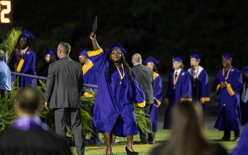 A graduate proudly holds up her diploma after walking off stage during commencement exercises Friday. (RAY CARPENTER/Special to the Reporter)