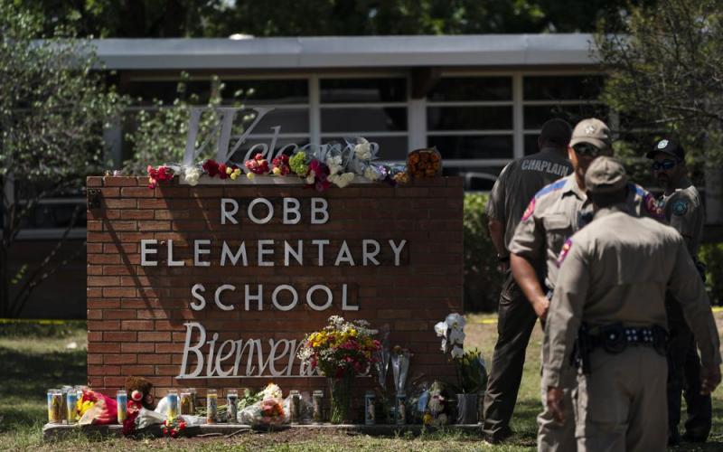 Flowers and candles are placed outside Robb Elementary School on Wednesday in Uvalde, Texas, to honor the victims killed in Tuesday's shooting at the school. (JAE C. HONG/Associated Press)
