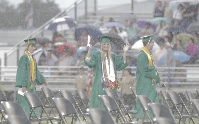 Caroline Simpson, the Suwannee High senior class vice president, walks into Langford Stadium during a downpour Saturday night. (JAMIE WACHTER/Lake City Reporter)
