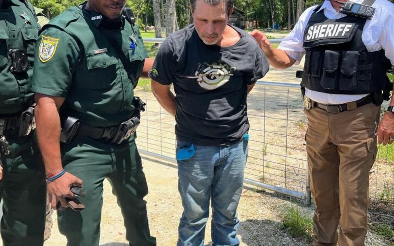 Daniel Scott Mobley Sr., center, was captured by the Suwannee County Sheriff’s Office on Thursday in the Three Rivers Estates following a tip to his location. Mobley is wanted for the armed robbery of a Dollar General on Tuesday. (COURTESY)