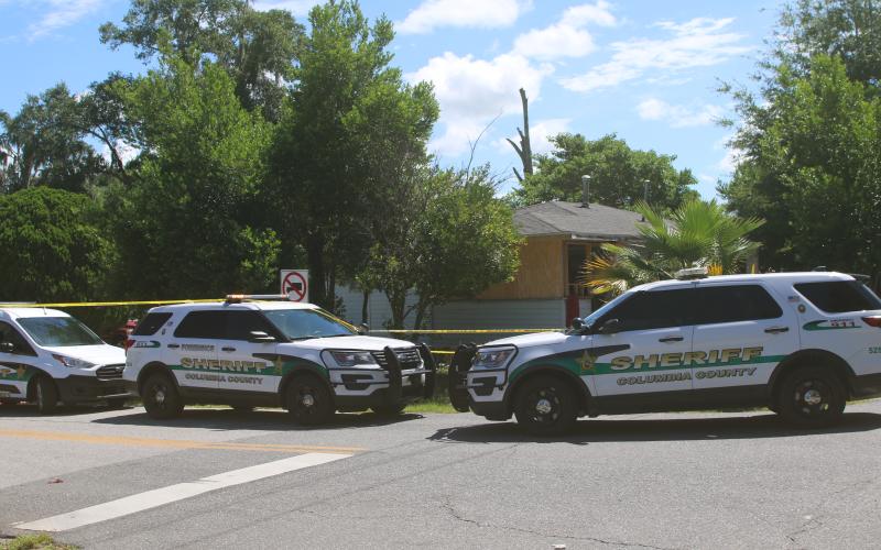 Columbia County Sheriff’s Office vehicles are parked outside a NW Long Street residence where a deputy was injured during a drug bust Wednesday morning. (TONY BRITT/Lake City Reporter)