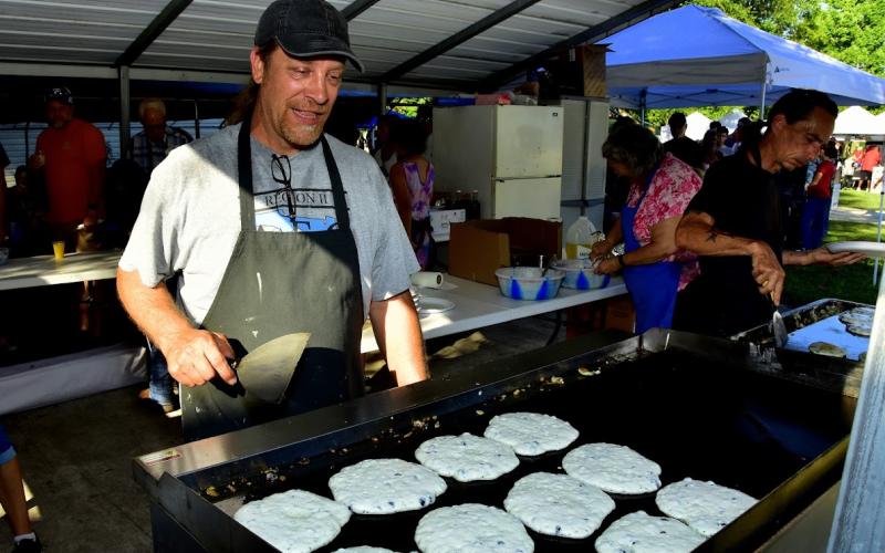 Rob Dawson with the Wellborn Community Association watches over a batch of blueberry pancakes Saturday morning during the 29th annual Wellborn Blueberry Festival. (ROB WOLFE/Special to the Reporter)