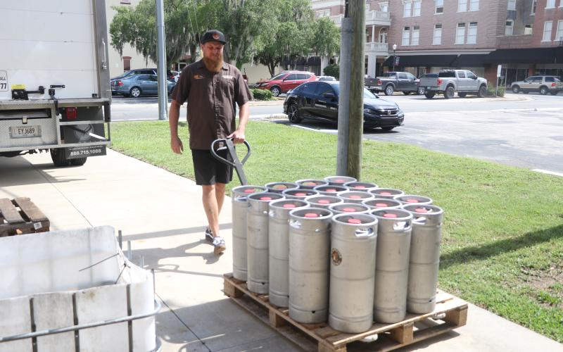 Jonny Frazier walks a pallet of 19 kegs of beer toward a Savannah Distributing truck near the loading ramp at Halpatter Brewing Company on Monday. (MORGAN MCMULLEN/Lake City Reporter)